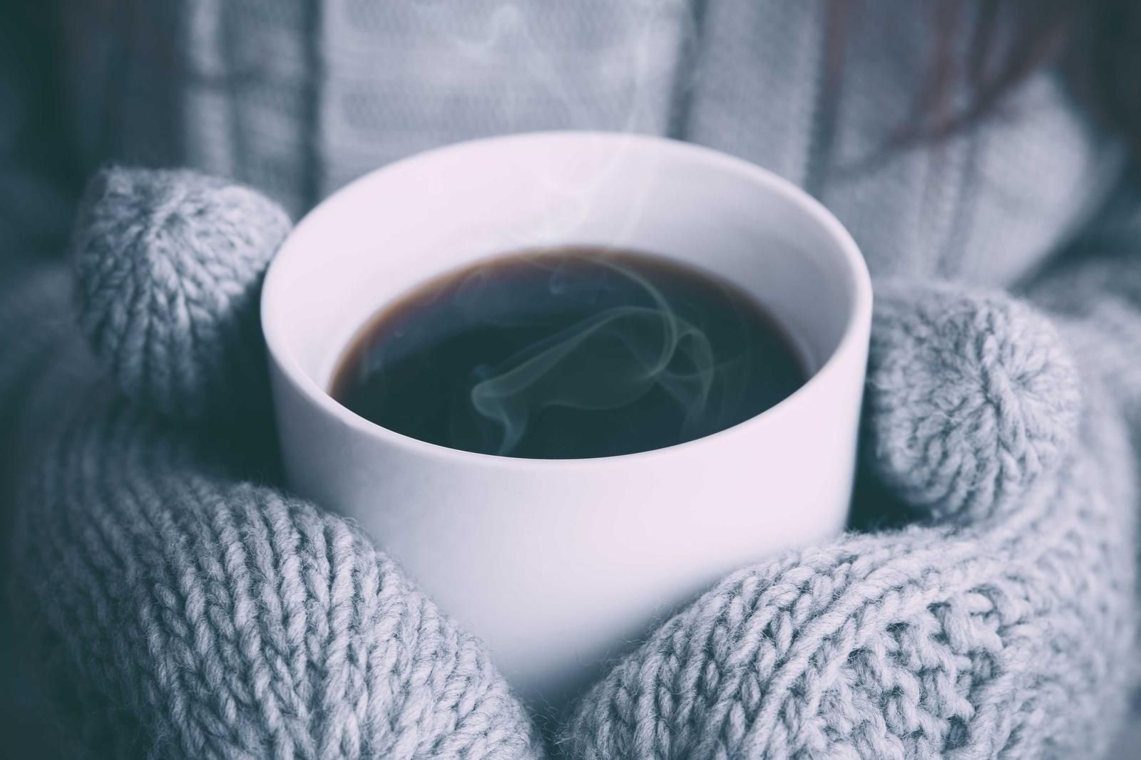 湯気の立つコーヒーを両手で包む