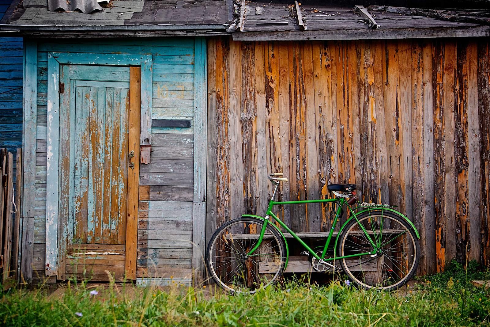 板張りの小屋と緑の自転車